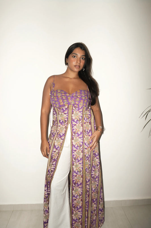 Model in purple printed front slit tunic with white pants against a white wall